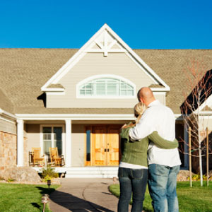 Couple is standing in front of house