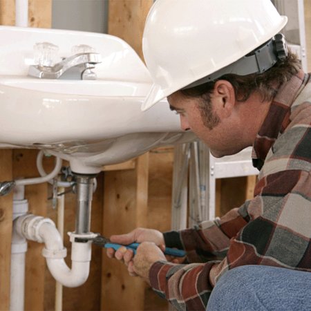 The plumber working under the sink in home at Euless, TX