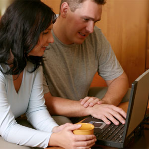 Happy couple working on laptop